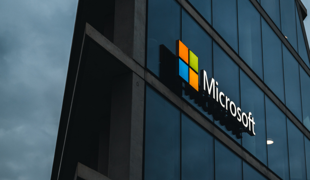 Microsoft logo on the site of a glass skyscraper.